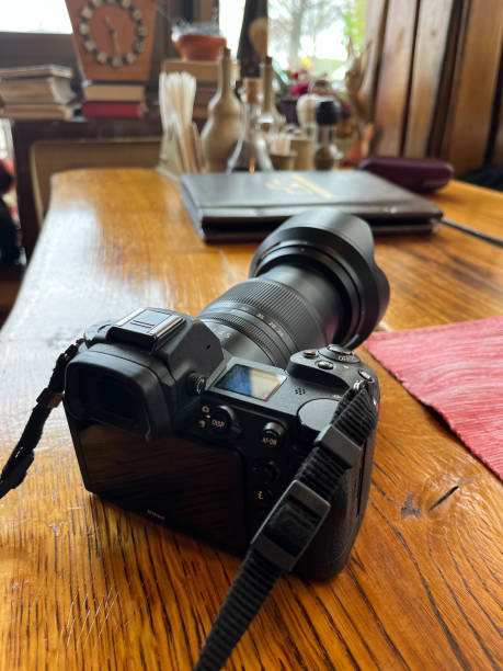 istock modern digital camera in black with a large lens on a wooden table. 1520091253