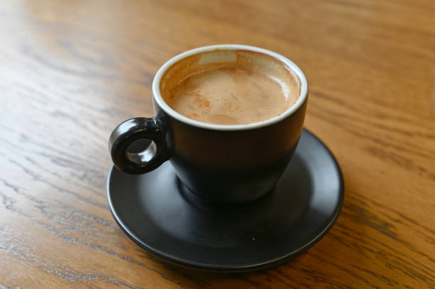 istock A black coffee cup with espresso coffee stands on a wooden table. close-up 1520108110
