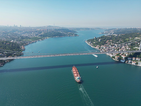 Aerial view of Cargo ship passing under The Second Bosphorus Bridge or Fatih Sultan Mehmet Bridge, Istanbul.