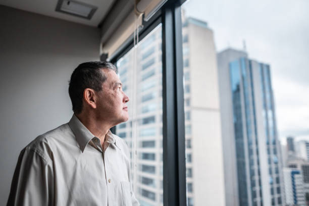 istock Senior businessman contemplating looking through the window at work 1520146290