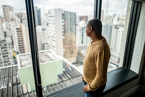 Businessman contemplating and looking through window at office