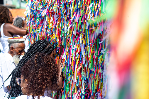 Salvador, Bahia, Brazil - January 06, 2023: Faithful pray in front of the grid of the church of Senhor do Bonfim on the traditional first Friday of 2023, in Salvador, Bahia.
