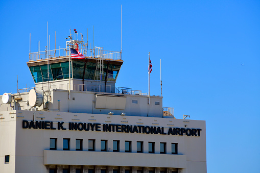 Top of Grey Airport Control Tower with Clouds and Blue Sky