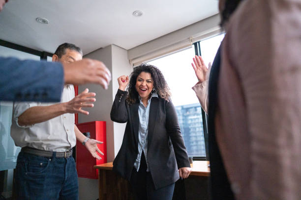 istock Coworkers celebrating with arms raised at office 1520215641