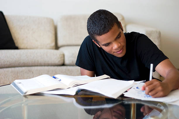 Teen Doing Homework 16 year old boy working on his homework. homework stock pictures, royalty-free photos & images