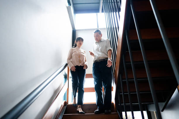 istock Coworkers talking and walking going down the stairs at office 1520219890