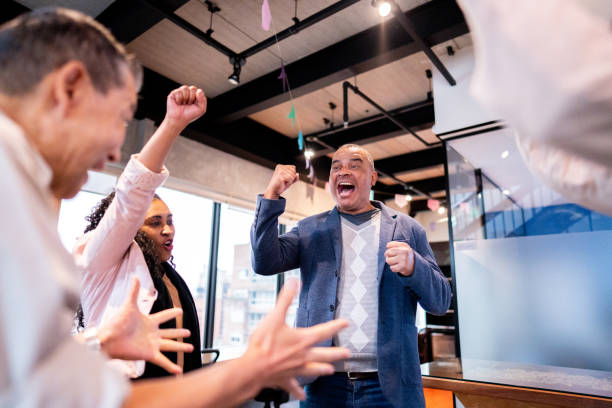 istock Coworkers celebrating with arms raised at office 1520222061