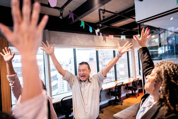 istock Coworkers celebrating with arms raised at office 1520224207