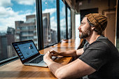 Mid adult man contemplating looking through window at office