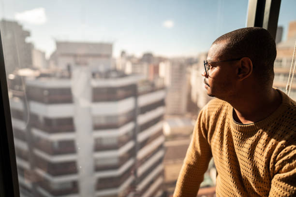 istock Mid adult man contemplating looking through the window 1520234591