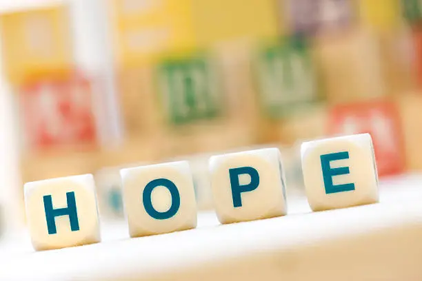 Close-up of the word "HOPE" spelled with Scrabble Tiles.