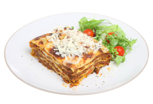 Beef lasagna topped with grated Parmesan and served with side salad