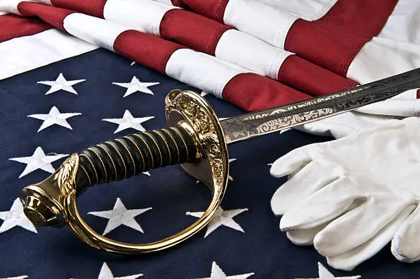 A sabre, white gloves, and an American flag symbolize the honor and duty of members of the United States Marine Corps.