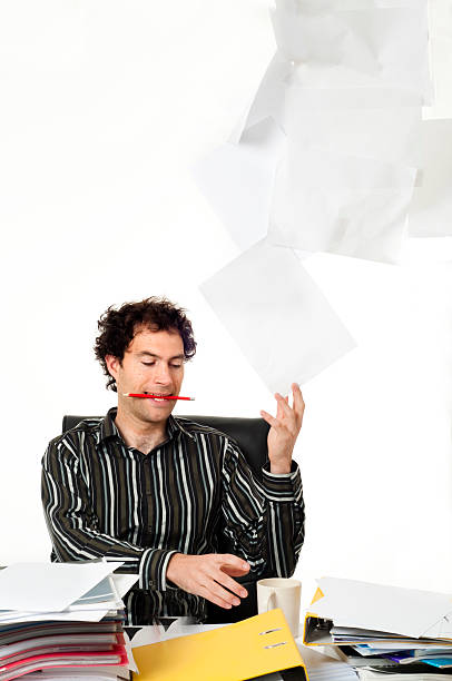 istock Man sitting at desk throwing up paperwork 152026648