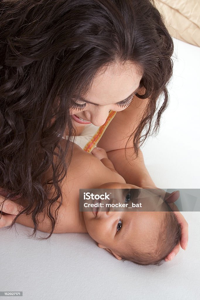 Latina mãe brincando com seu bebê menino filho na cama, - Foto de stock de Mãe royalty-free