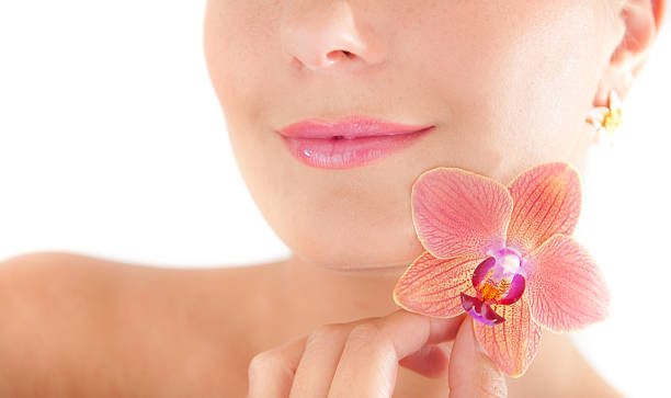 woman with healthy skin and orchid flower stock photo