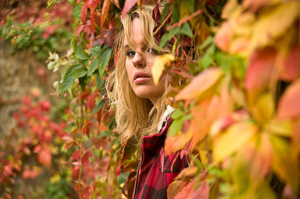 young girl in autumn leafs stock photo