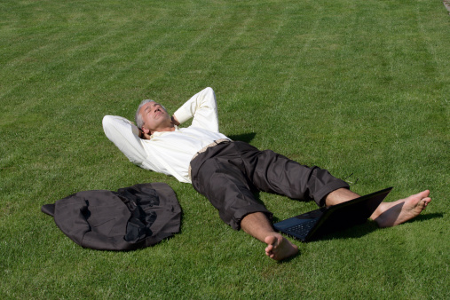Handsome businessman lying down on grass