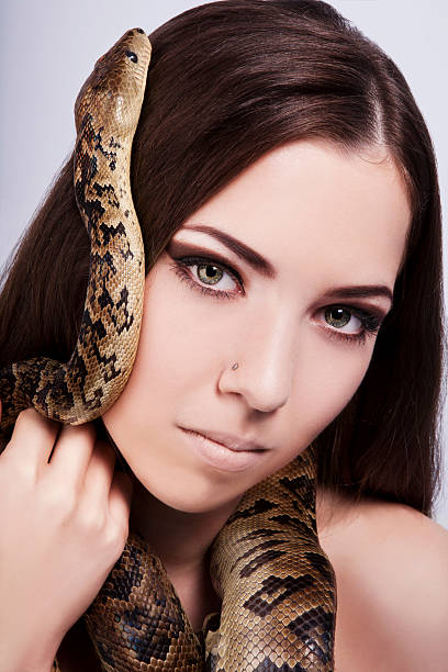 istock beautiful brunette girl with a snake around her head 152030932