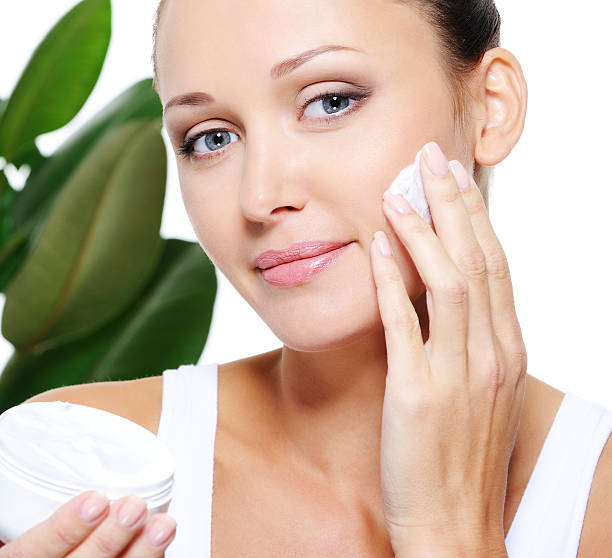 istock Woman holding moisturizer cream and applying it on her face 152031037