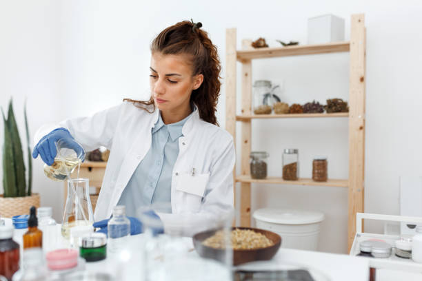 istock Young beautiful woman in lab coat working at her organic cosmetic workshop 1520318251