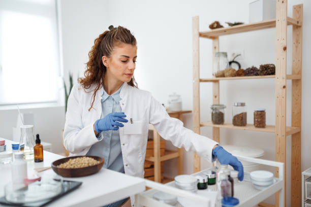 istock Young beautiful woman in lab coat working at workshop 1520320012