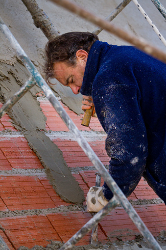Construction worker placing cement with a trowel on the wall - Buenos Aires - Argentina