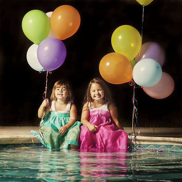 Girls setting by the pool stock photo