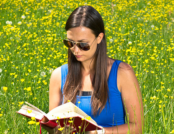 istock Girl reading a book in the park 152044250