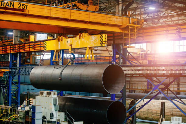 istock Finished pipe transportation by overhead crane in pipe factory 1520475347