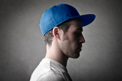 Profile of a handsome young man wearing a peaked cap