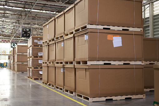 A warehouse filled with lots of boxes and boxes stacked on top of each other, a Logistics warehouse. Spacious component part with boxes. Industrial building with goods on pallets. Cardboard boxes are stacked on top of each other. Warehouse industrial company.