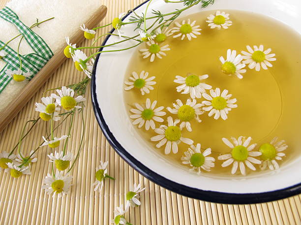 Bath essence with chamomile flowers stock photo
