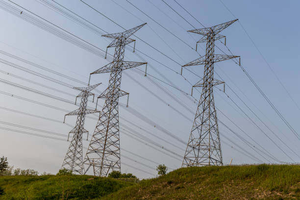 High voltage power lines - metal power grid - grass hill background. Taken in Toronto, Canada.