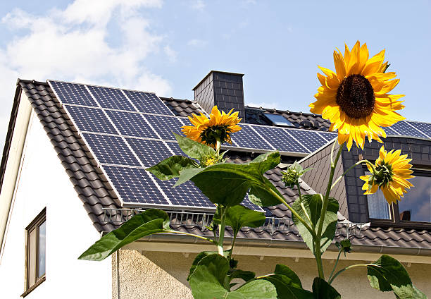 Solar panels at a roof with sun flowers stock photo