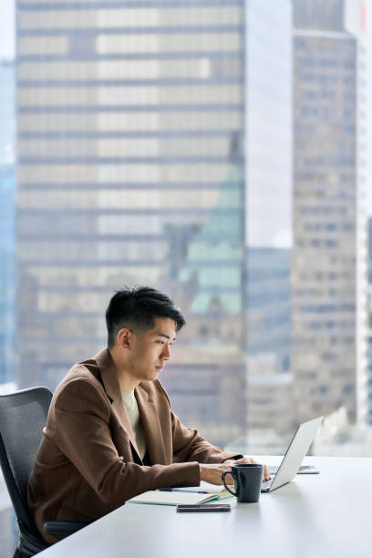 istock Young serious busy Asian business man typing on laptop using computer in office. 1520623711