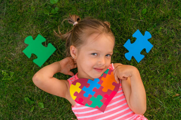 istock Preschooler is lying on the grass surrounded by puzzles with a heart-shaped card 1520738078