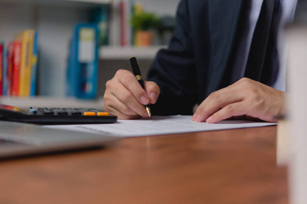 istock person document writing on paper with a pen, Man worker signing job contract, note, insurance and report concept. 1520767353