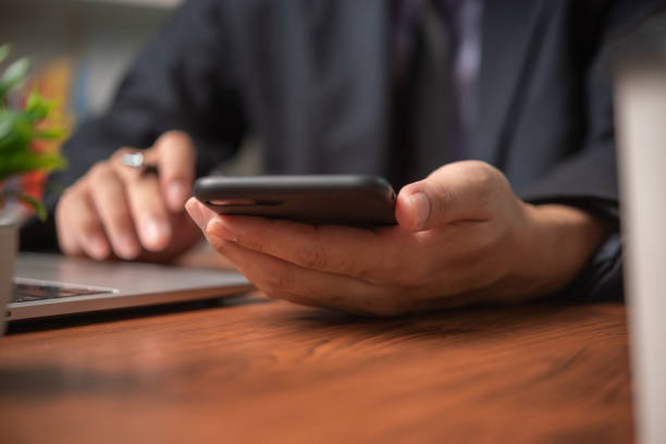 istock Business man using mobile smart phone management information financial documents, marketing online, job and payment digital technology on desk. 1520767355