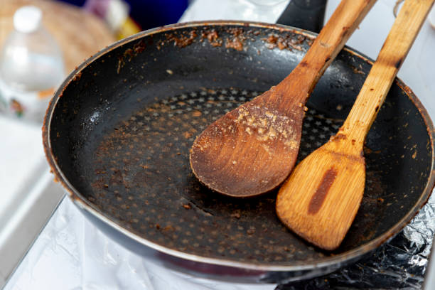istock Empty black round cast iron pan with a spatula and a wooden spatula that had just finished cooking on the stove in the middle of the day 1520913722