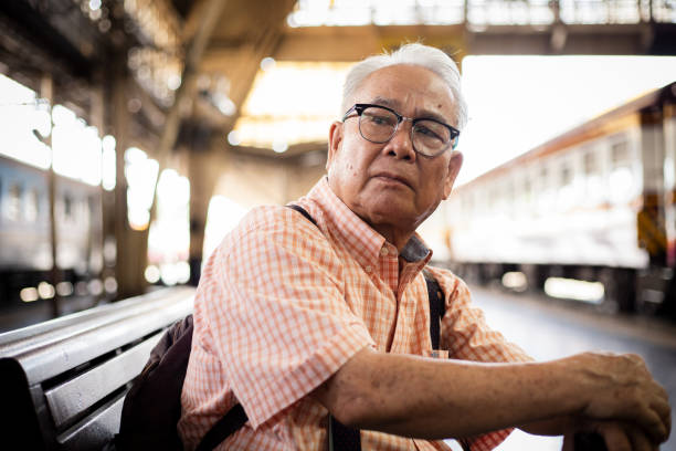 istock Lonely Asian tourist eldery man with backpack at train station. 1520950473