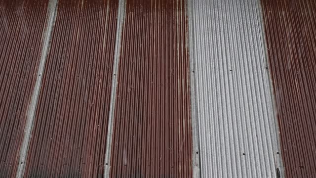 Rain drop on an old rusty metal sheet roof during raining season.