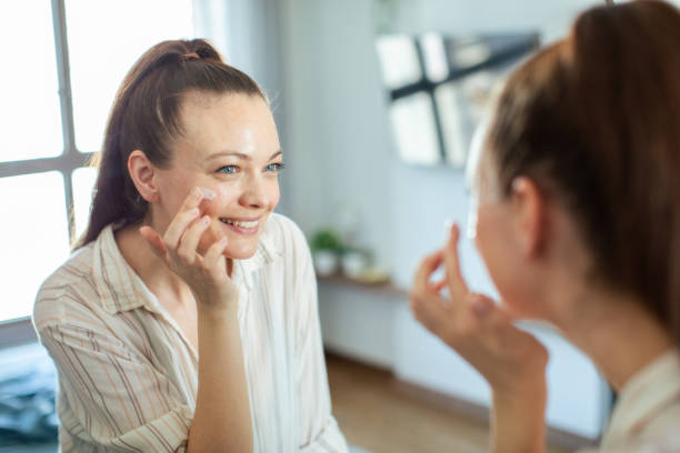 istock Young woman putting on makeup while looking in a mirror at home 1520977645