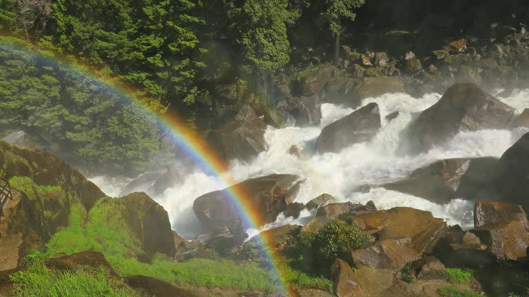 Powerful flowing water from rushing river and flooding with rainbow in Yosemite National Park