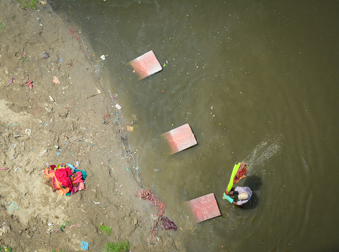 People washing and drying colorful sarees (Indian traditional dress) on the river bank in Agra, India.