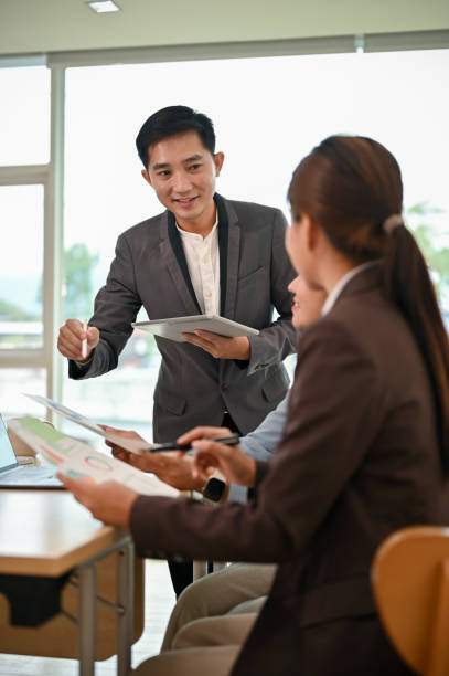 istock A professional Asian male boss sharing his ideas and discussing work with his employees 1521089842