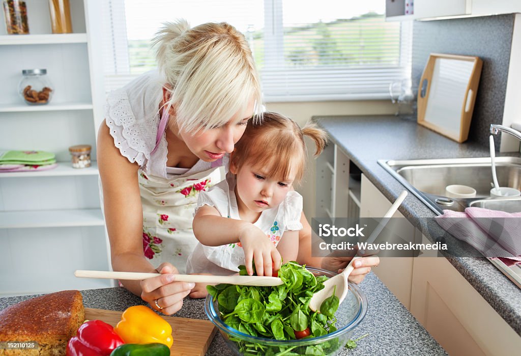 Sorgfältige Mutter und Tochter einen Salat vorbereiten - Lizenzfrei Abnehmen Stock-Foto