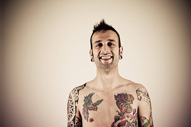 Topless Tattooed Man Smiling Studio portrait of a tattooed man smiling at the camera. Horizontal shot. chest tattoos for men designs stock pictures, royalty-free photos & images
