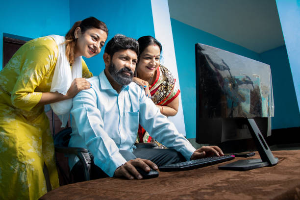 istock Traditional indian Man with his wife and daughter using computer. Learn skills, Technology in rural household. 1521120435