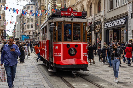 Taksim Tram navigating Istiklal Avenue through a crowed on a busy spring afternoon.